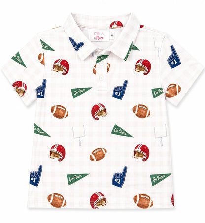 A short-sleeve polo shirt for kids by Mila & Rose, featuring a white base with a subtle plaid pattern and an all-over sports print of football helmets, footballs, pennants, and foam fingers.